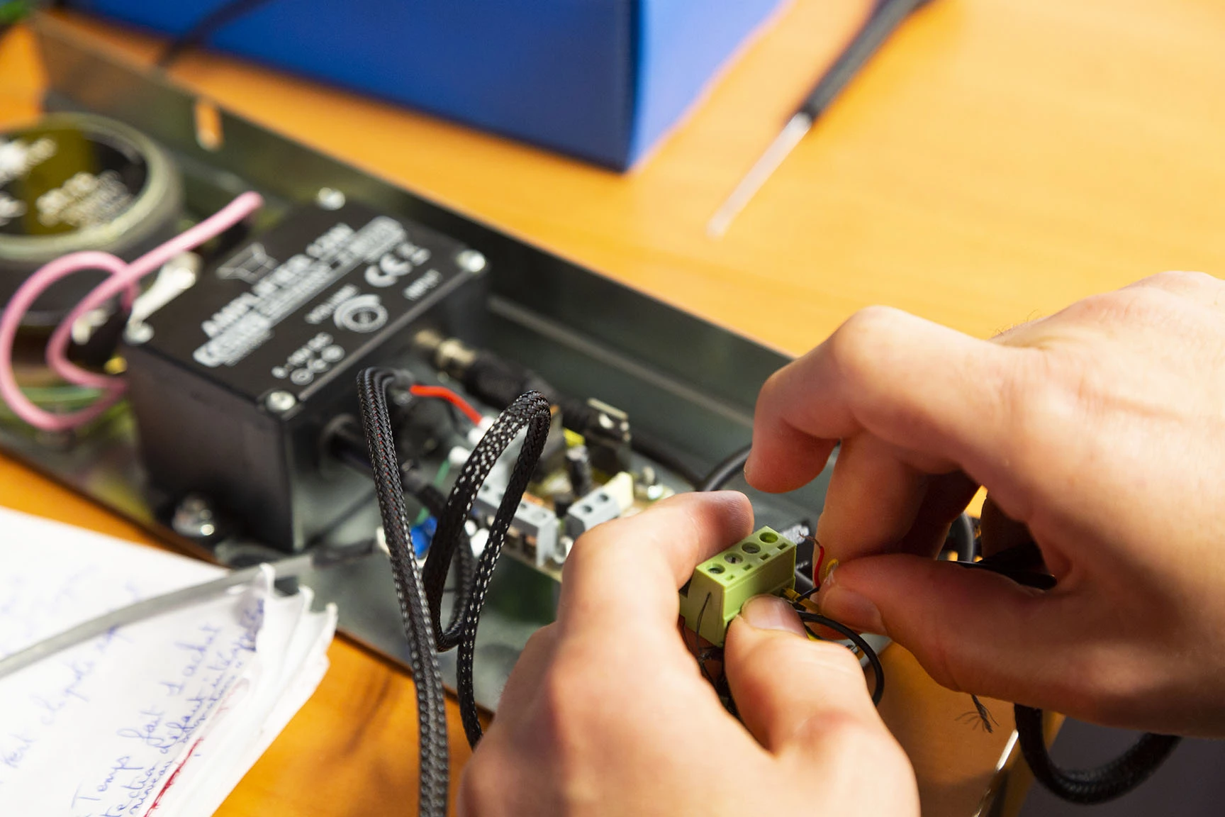 Une personne travaillant sur un circuit électronique avec des fils et des composants sur une table.